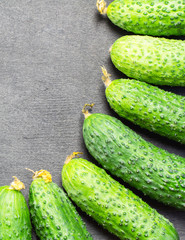 Cucumbers on a black wooden background 