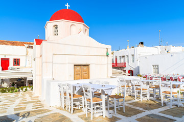 Typical Greek white church and taverna tables in Mykonos town, island, Greece