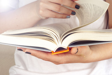 Young girl reading an open old book. Knowledge, Science. Toned image.
