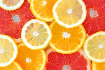 Background of citrus fruit slices, with lemons, oranges and grapefruit