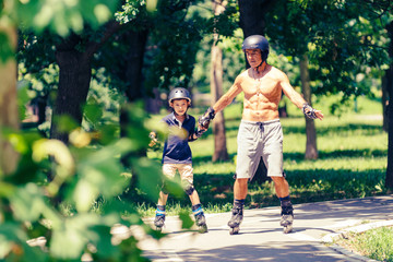 Little boy learning roller skating in park