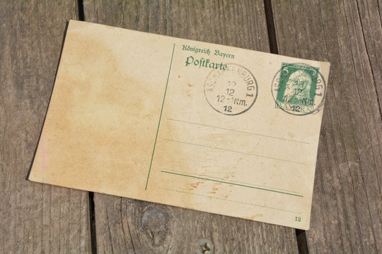 alte leere Vintage Postkarte mit alter Briefmarke liegt auf altem Holz 