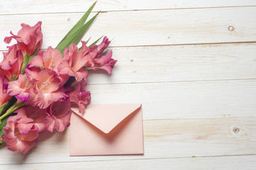 Colorful flowers in envelope, flower delivery concept. The word love a lot of hearts on wooden background. congratulate