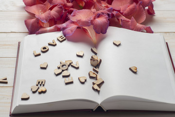 The word love a lot of hearts, flowers on a background of book on a wooden table. Back to school copy space. Education background.