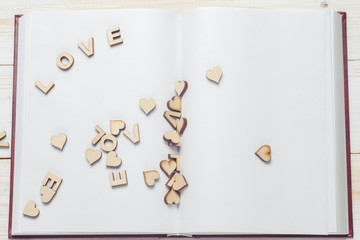 The word love a lot of hearts on a background of book on a wooden table. Back to school copy space. Education background.