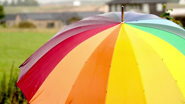 A person with colorful umbrella in the rain - 1080p HD video 