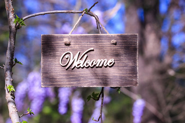 Welcome sign hanging from tree © laurha
