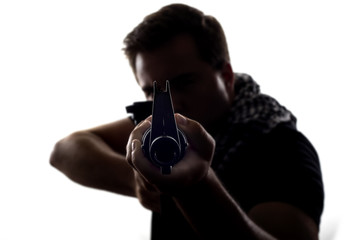 Silhouette of a model posing as a military soldier with a rifle and shemagh scarf