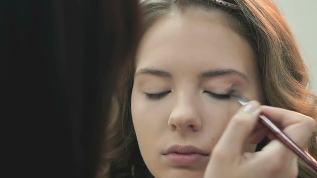 Makeup artist making make-up for the stylish bride