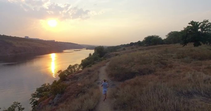 Drone film of young sport couple jogging together in countryside