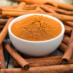 Cinnamon sticks and powder cinnamon in the bowl on table
