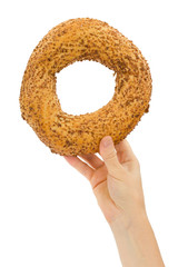 Female hand holding fresh bagel, isolated on white background