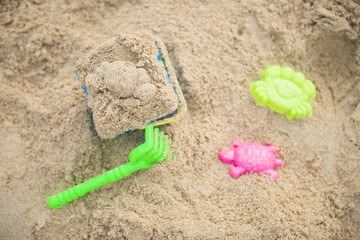 Fototapeta na wymiar colorful toys for kids on sand