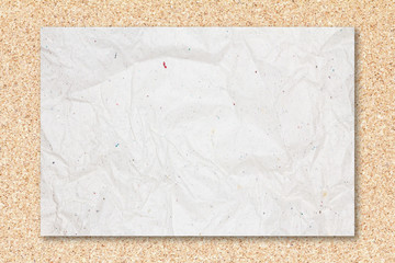 Recycled crumpled white paper on cork board background.