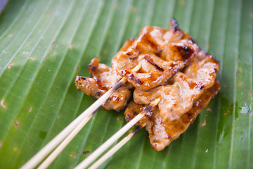 Roasting pork skewers on banana leaf