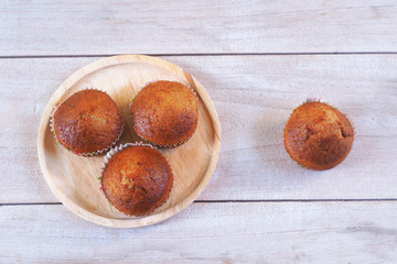 Obraz premium Top view of homemade banana cupcakes on a wooden table.
