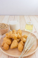 soybean milk in glass and youtiao on wood plate