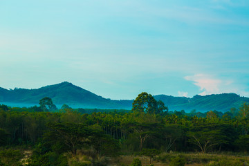 Fototapeta premium Misty morning sunrise of hilly area with ray of light.