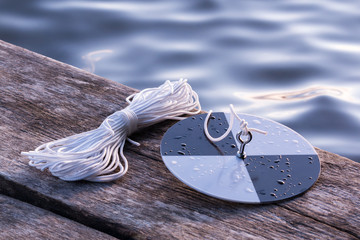 Water transpacency measurement disk with rope on a wooden dock
