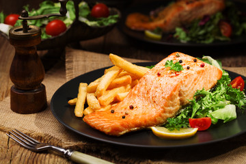 Baked salmon served with french fries.
