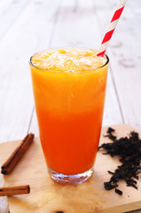 Close up of iced chai masala tea on a wooden background.