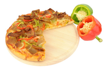 Doner meat and sweet pepper pizza on a wooden cutting board