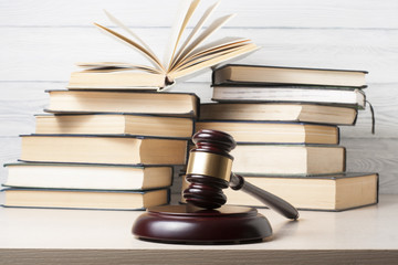 Law concept - Book with wooden judges gavel on table in a courtroom or enforcement office.