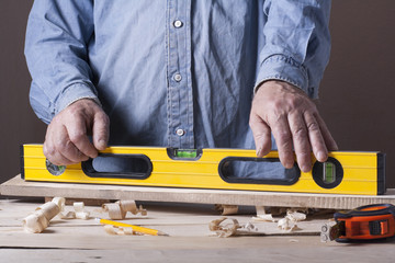 Carpenter working with plane on wooden background at Building Site. Joiner workplace