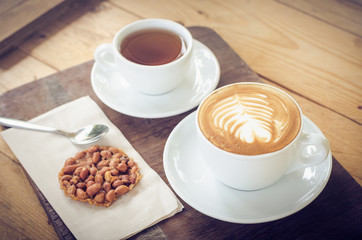 Coffee cup and tea on table with snack