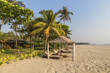 Obraz na płótnie Canvas Coconut palm leafs on a perfect white beach in front of Sea.