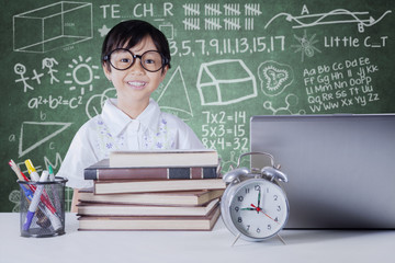 Child with books and notebook in class