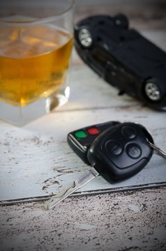 Car keys, glass of whiskey in background