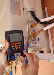 Instalador verificando el compresor de aire acondicionado