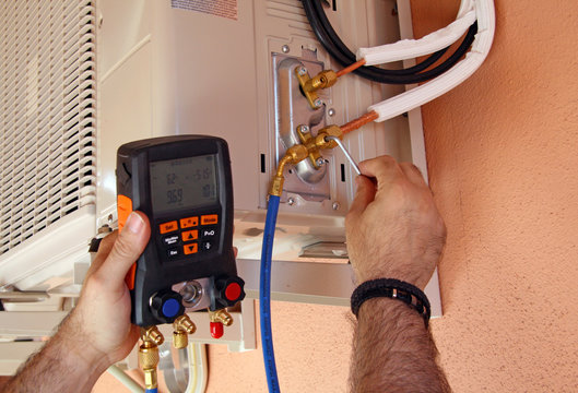Instalador verificando el compresor de aire acondicionado