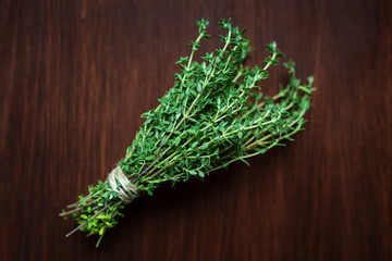 Fresh green bunch of thyme on wooden background