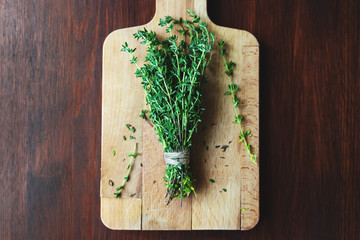 Fresh green bunch of thyme on wooden background