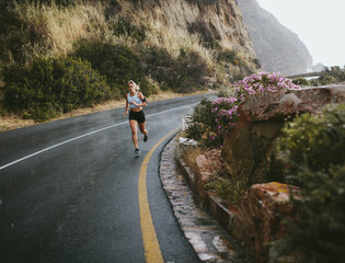 Fitness woman running outdoors on highway