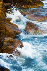 The charming landscape of the sea splashing on the rocks