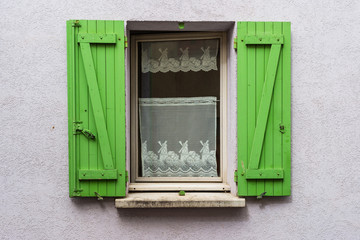 Detail of Vintage green wooden shutters window with windmill curtains 