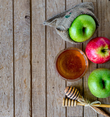 Honey and apples on wood deck for Rosh Hashanah celebration. Jewish New Year Holiday.