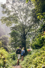 Obraz premium Couple of tourists walking along the forest trail