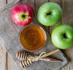 Honey and apples on wood deck for Rosh Hashanah celebration. Jewish New Year Holiday.