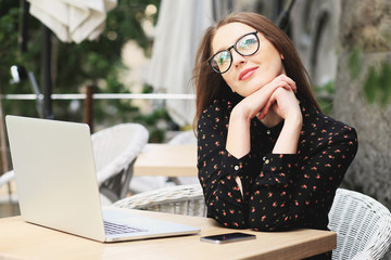 Business women wearing glasses and black shirt in the cafe is dreaming