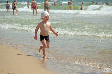 boy frolics in the sea with splashes and waves