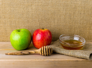 Honey and apples on wood deck for Rosh Hashanah celebration. Jewish New Year Holiday.