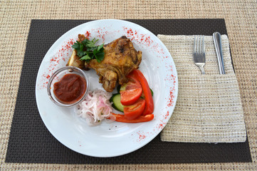 Chicken of a barbecue with a garnish from fresh vegetables