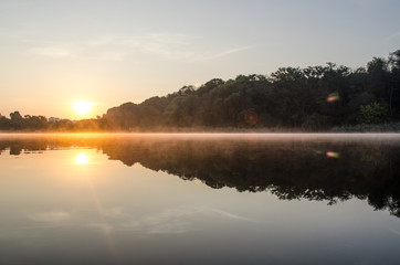 Sunrise above the lake in the forest