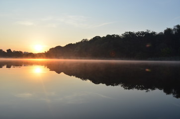 Sunrise above the lake in the forest