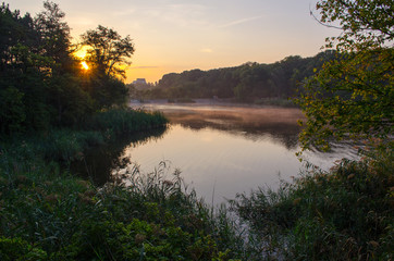 Obraz na płótnie Canvas Sunrise above the lake in the forest