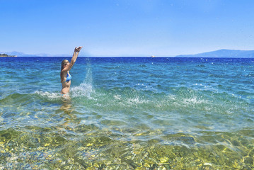 greek girl iside the sea playing with the waves at Euboea Greece